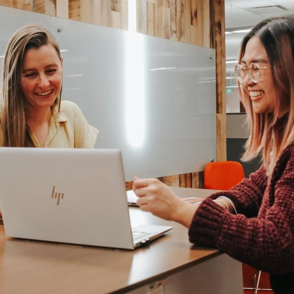 Two GM employees working together on a laptop.